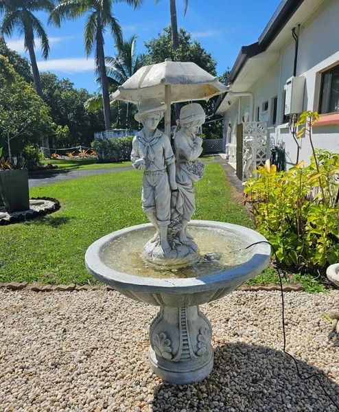 Fountain With Two Figures Under an Umbrella, Water Flowing — Villa Lamor in Balberra, QLD