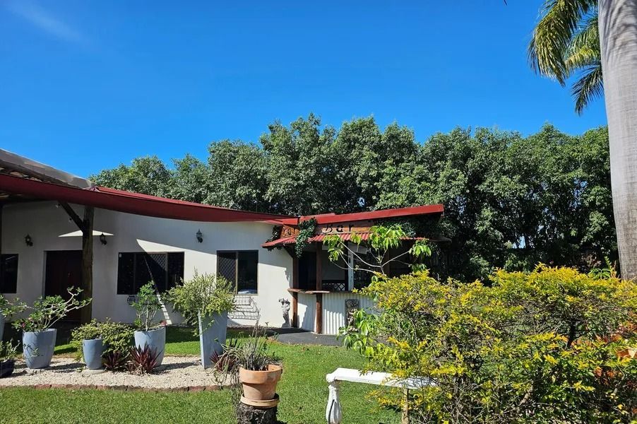 A House With a Red Roof, Surrounded by Trees and a Green Lawn — Villa Lamor in Balberra, QLD