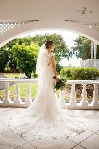 Bride in White Dress, Holding Bouquet, Standing on a Porch With Green Foliage — Villa Lamor in Balberra, QLD