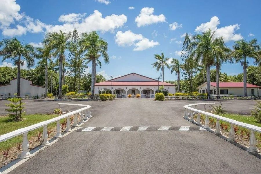 Driveway Leading to a White Building With a Red Roof and Palm Trees — Villa Lamor in Balberra, QLD