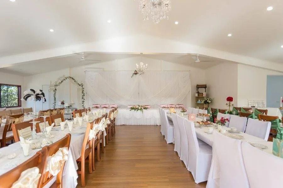 Wedding Reception Hall, Long Tables Set for Guests, White Tablecloths, and Floral Centerpieces — Villa Lamor in Balberra, QLD