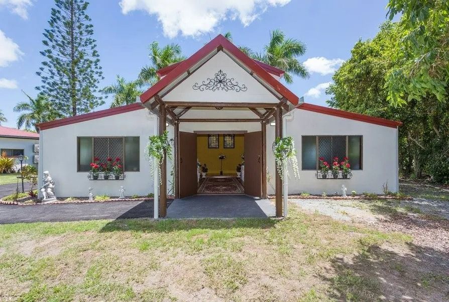 White Building With Red Roof, Porch. Windows With Flower Boxes, and Green Lawn — Villa Lamor in Balberra, QLD