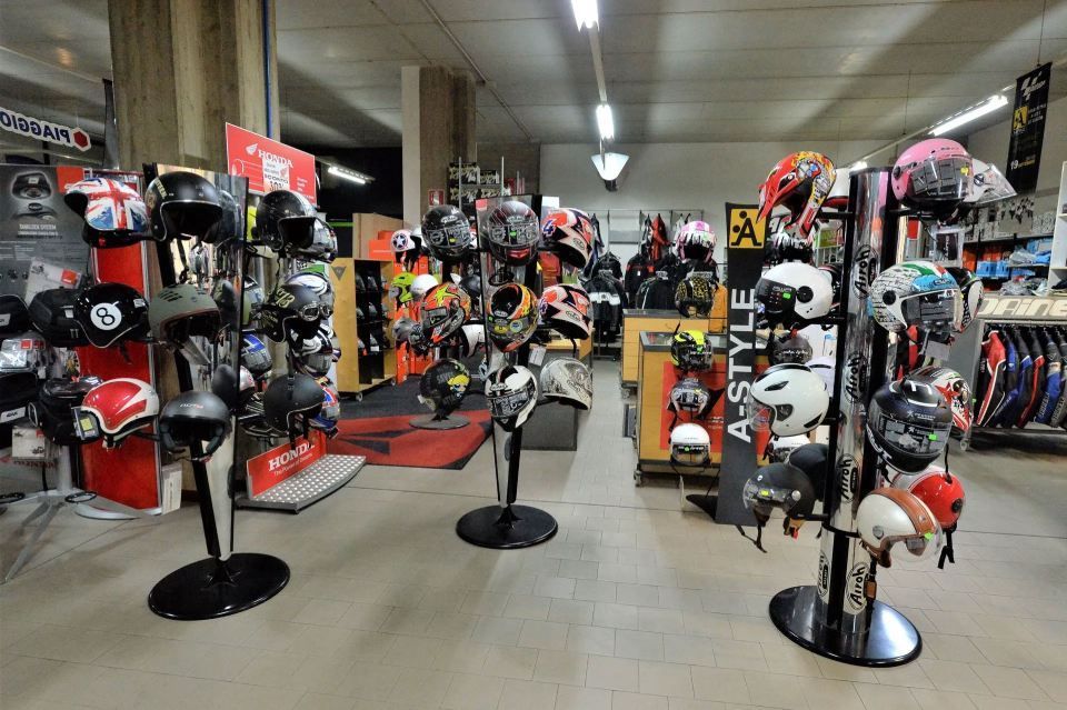 Caschi da motociclista esposti in un negozio al dettaglio. Caschi neri, bianchi e rossi esposti su espositori.