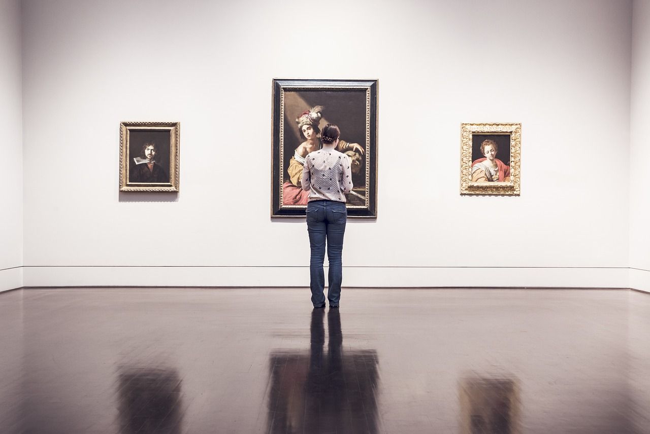 a woman is looking at a painting in a museum .