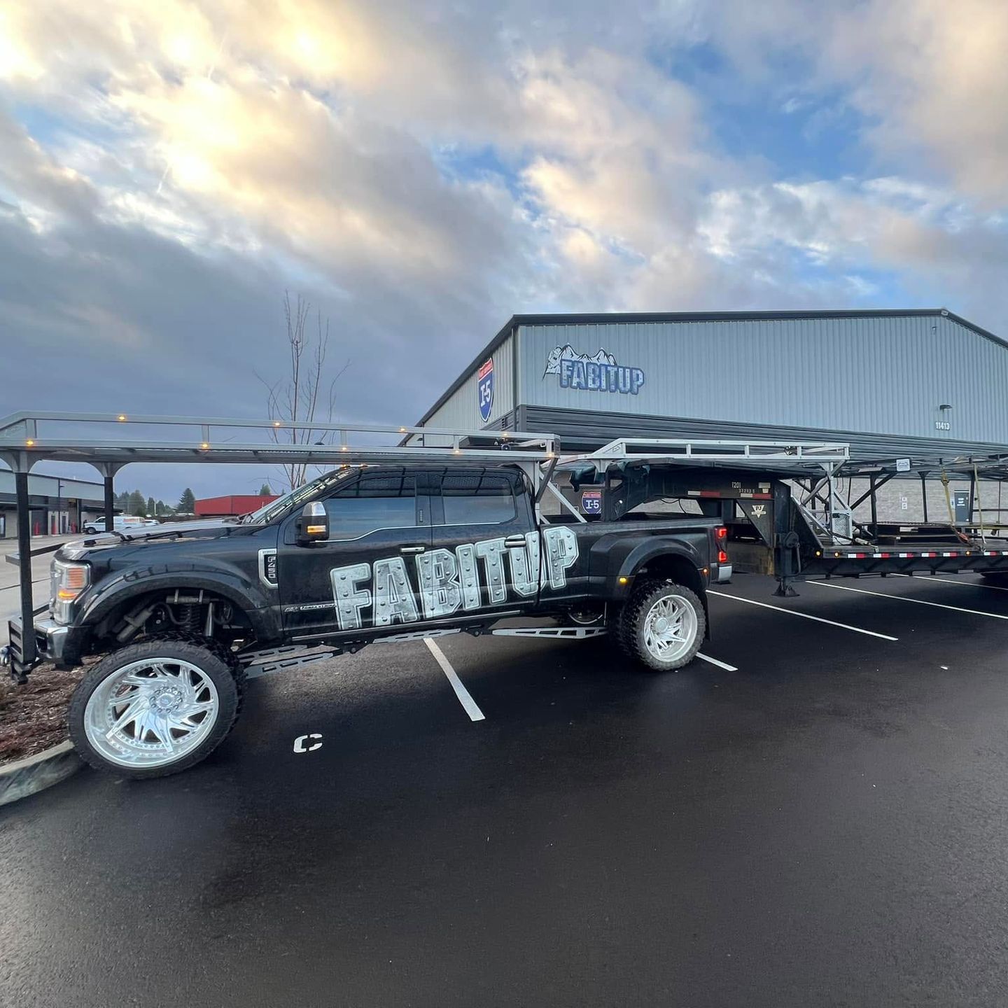 A truck is parked in a parking lot in front of a building.