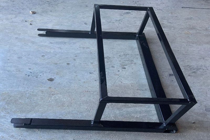 A metal frame is sitting on a concrete floor