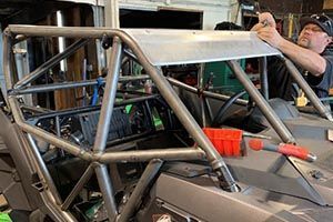 A man is working on a vehicle in a garage.