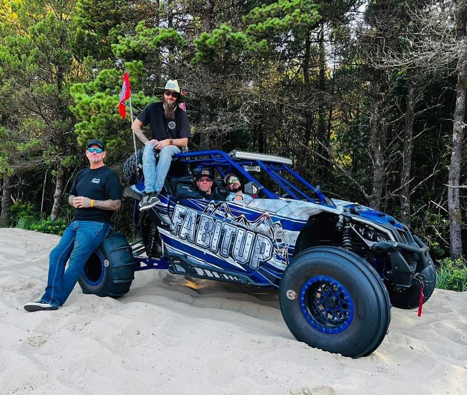 Two men are sitting on top of a blue and white buggy.