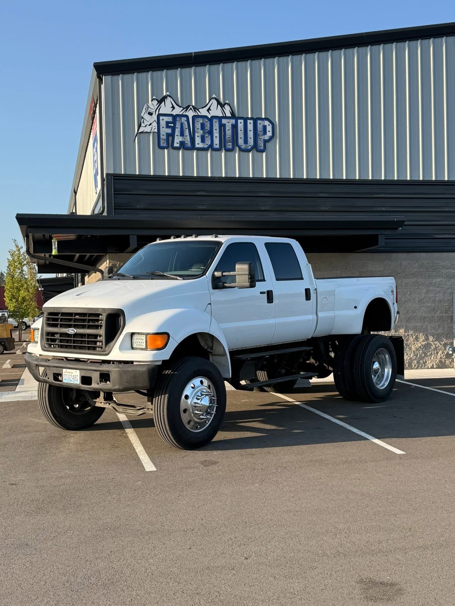 A white pickup truck is parked in front of a building.