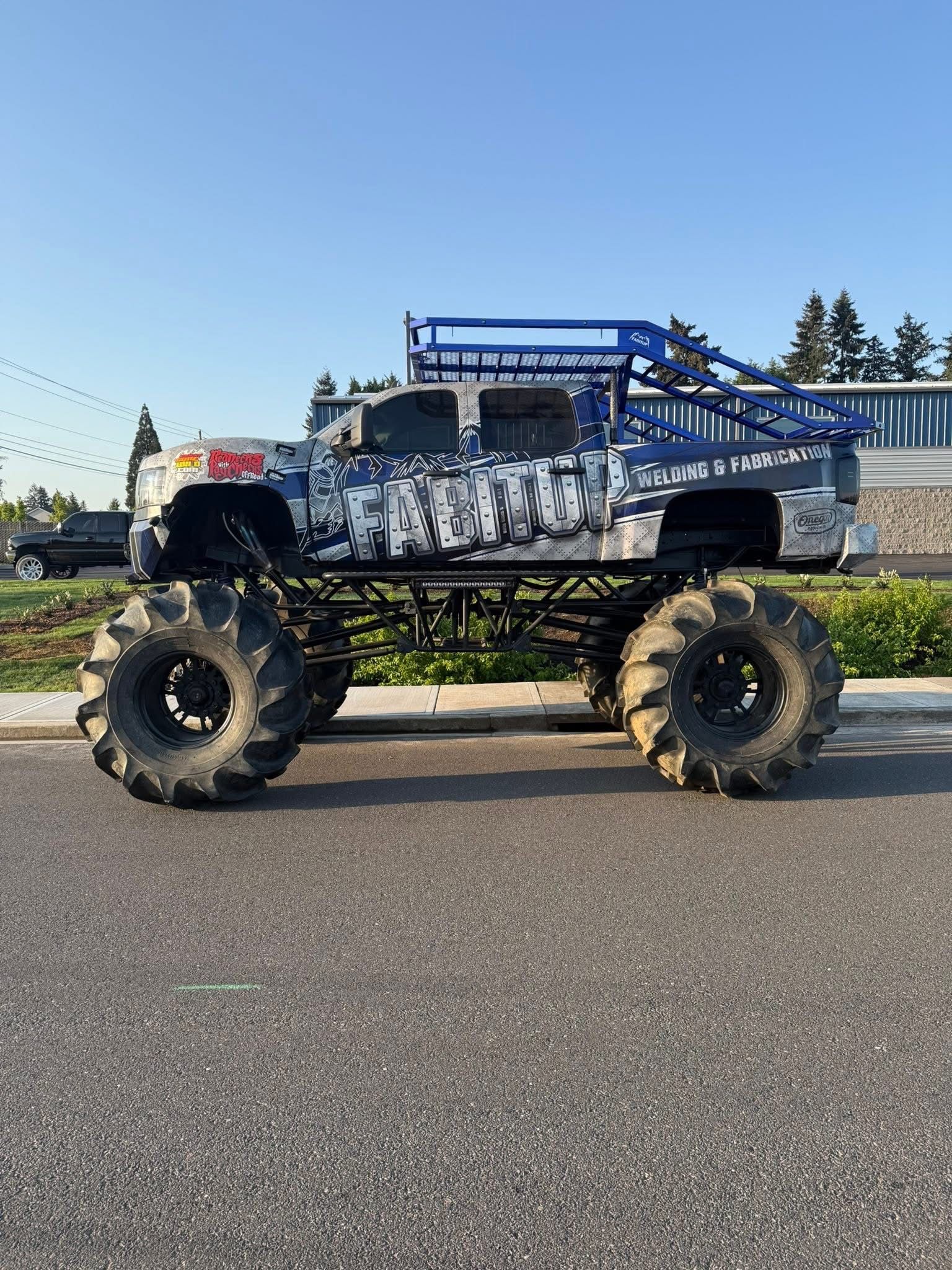 A monster truck is parked on the side of the road.