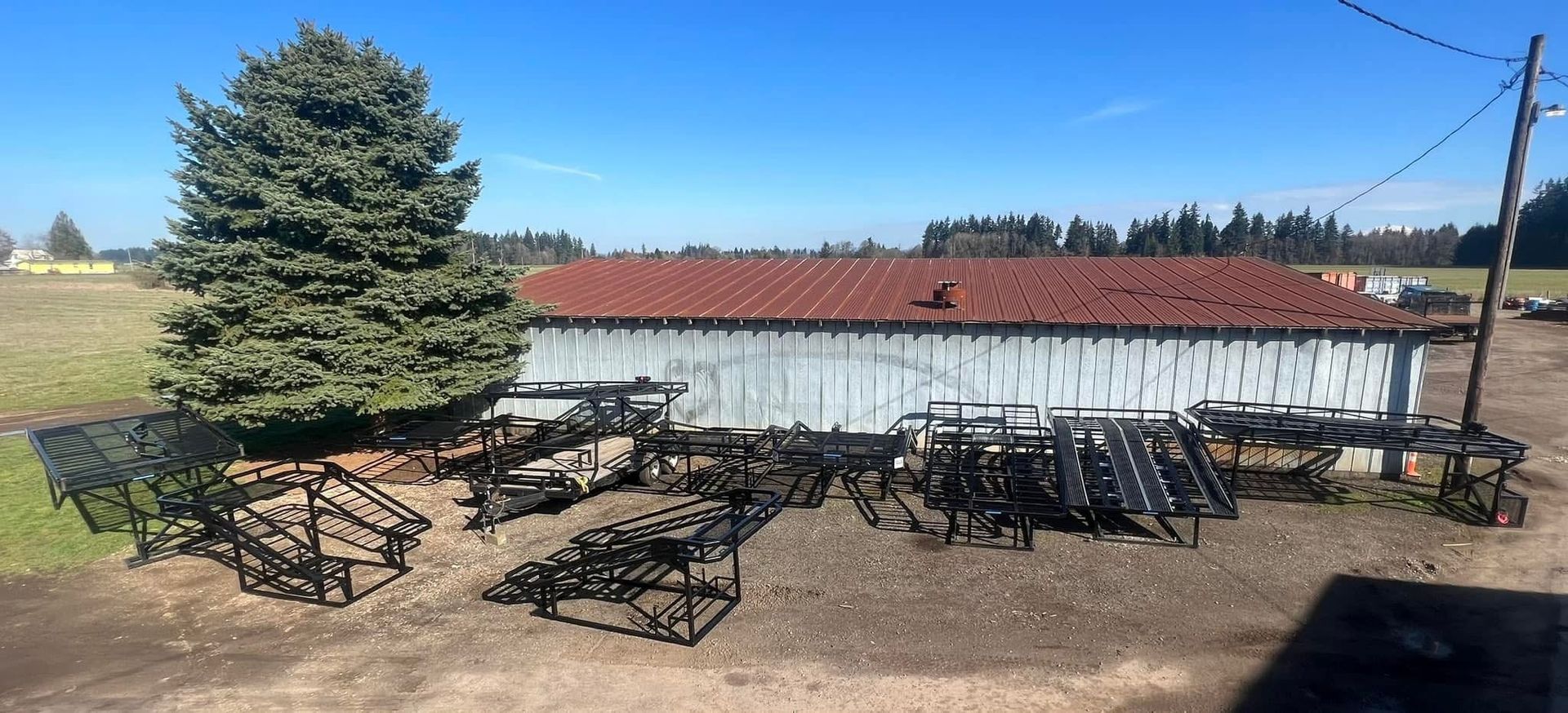A large white building with a red roof is sitting in the middle of a field.