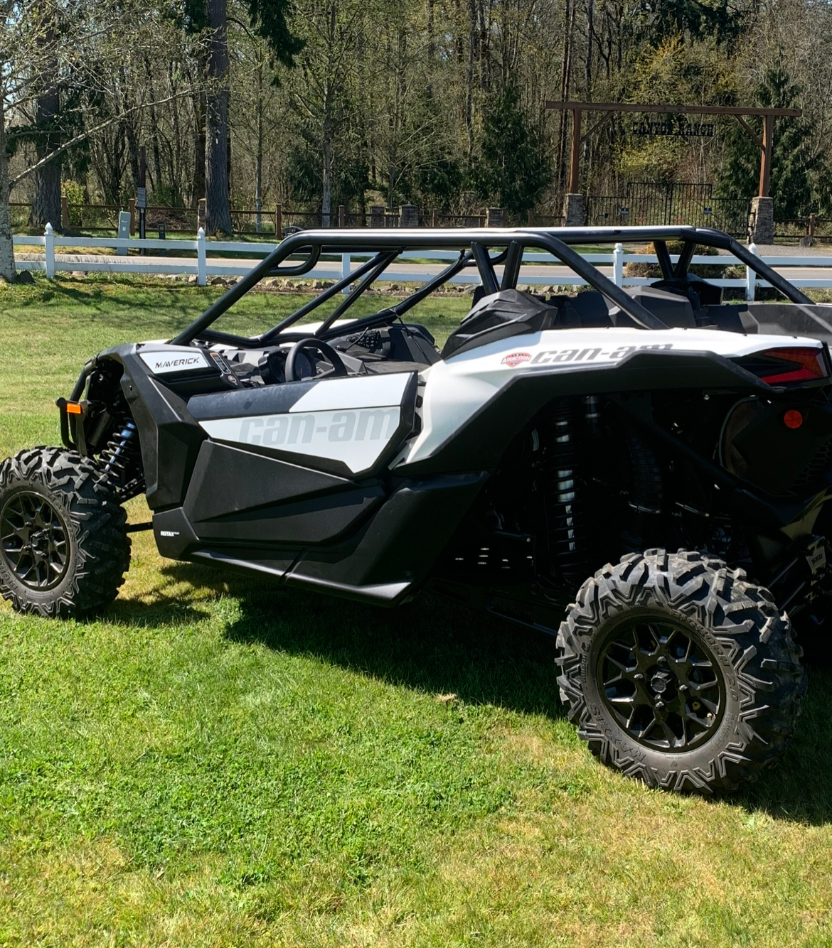 A black and white atv is parked in a grassy field.