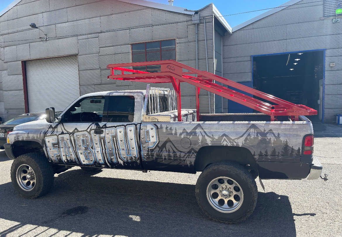A white truck is parked in front of a building.