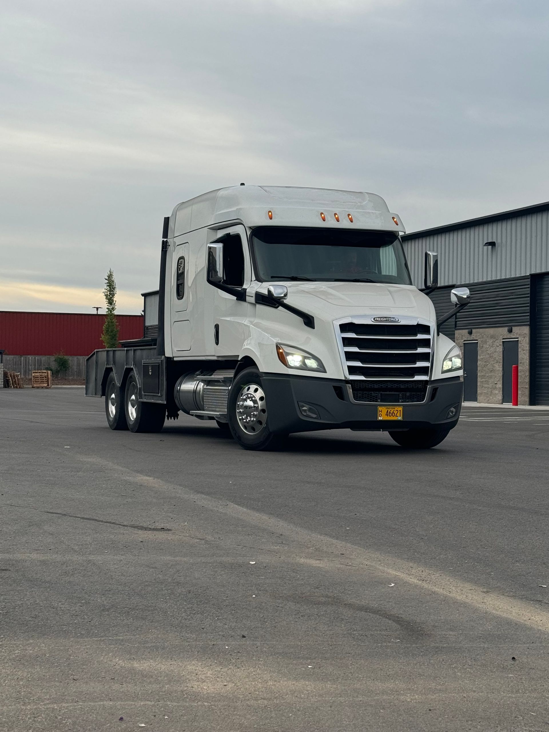 A white semi truck is parked in a parking lot.