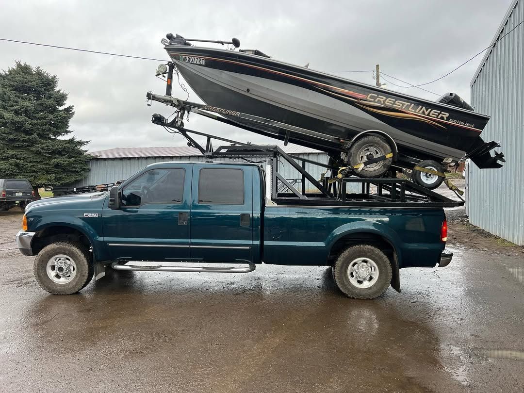 A truck is carrying a boat on top of it.