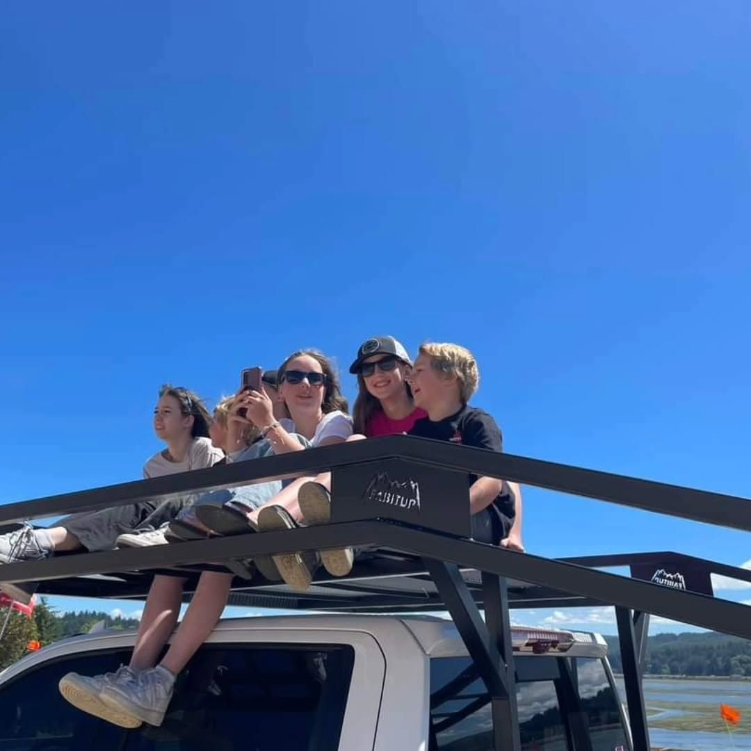 A group of people are sitting on the roof of a truck