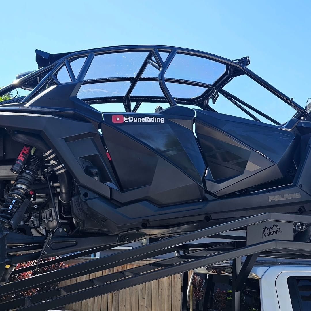 A black atv is being towed by a tow truck.