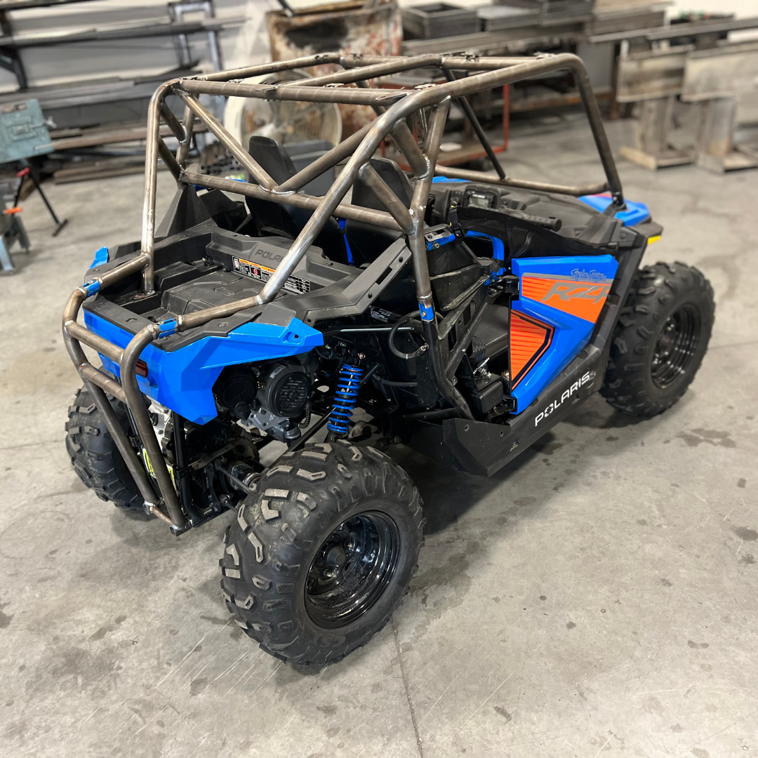 A blue and black atv is parked in a garage.