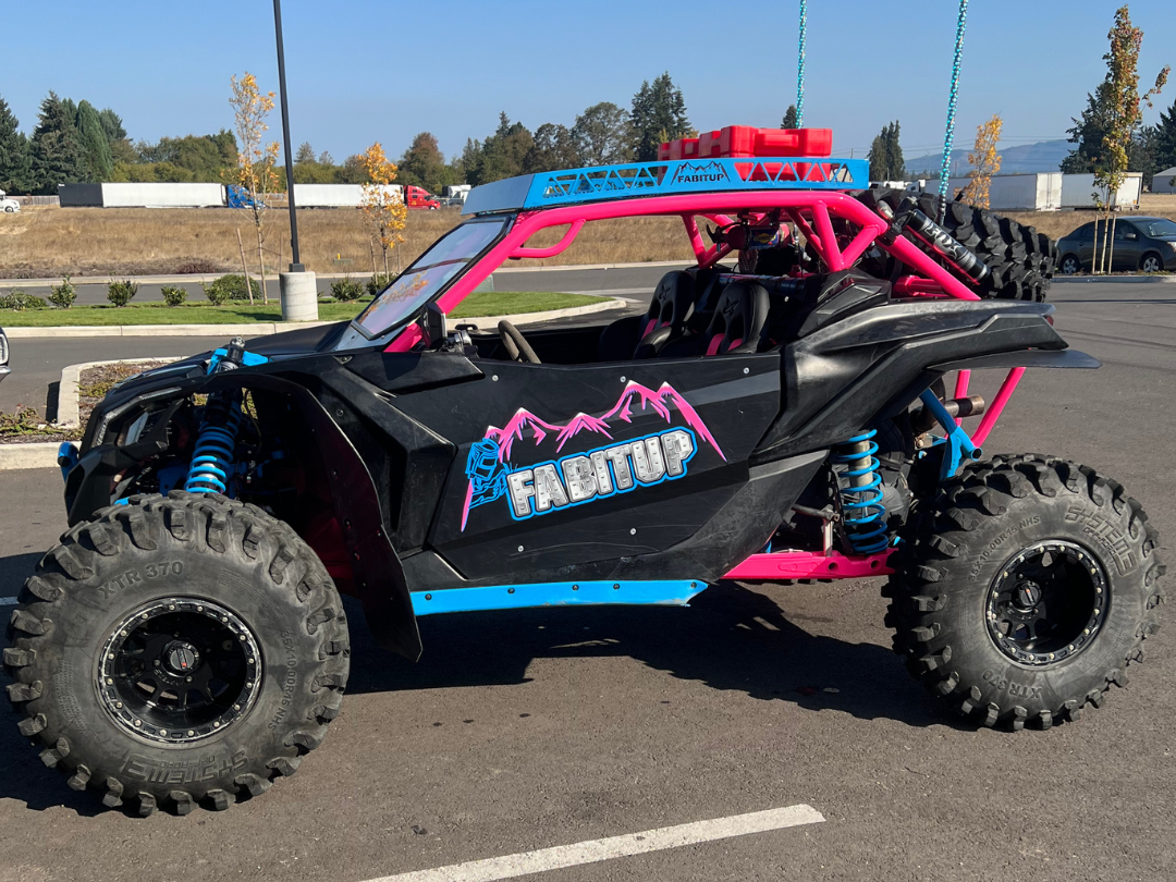 A black and pink atv is parked in a parking lot