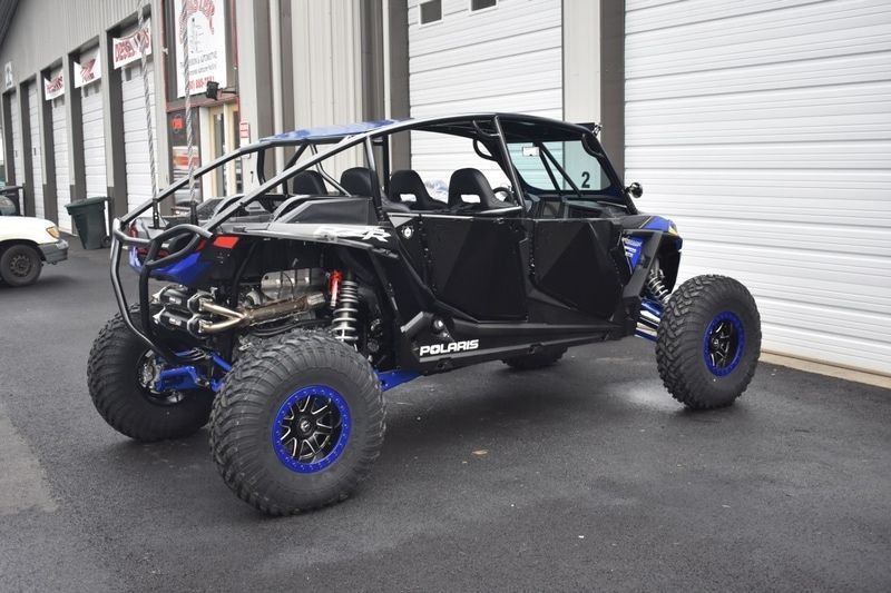 A black and blue atv is parked in front of a building.
