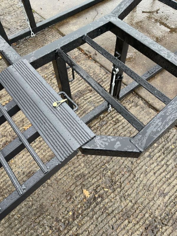 A metal frame with stairs attached to it is sitting on the ground.
