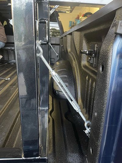 A close up of a truck bed with a rope attached to it.