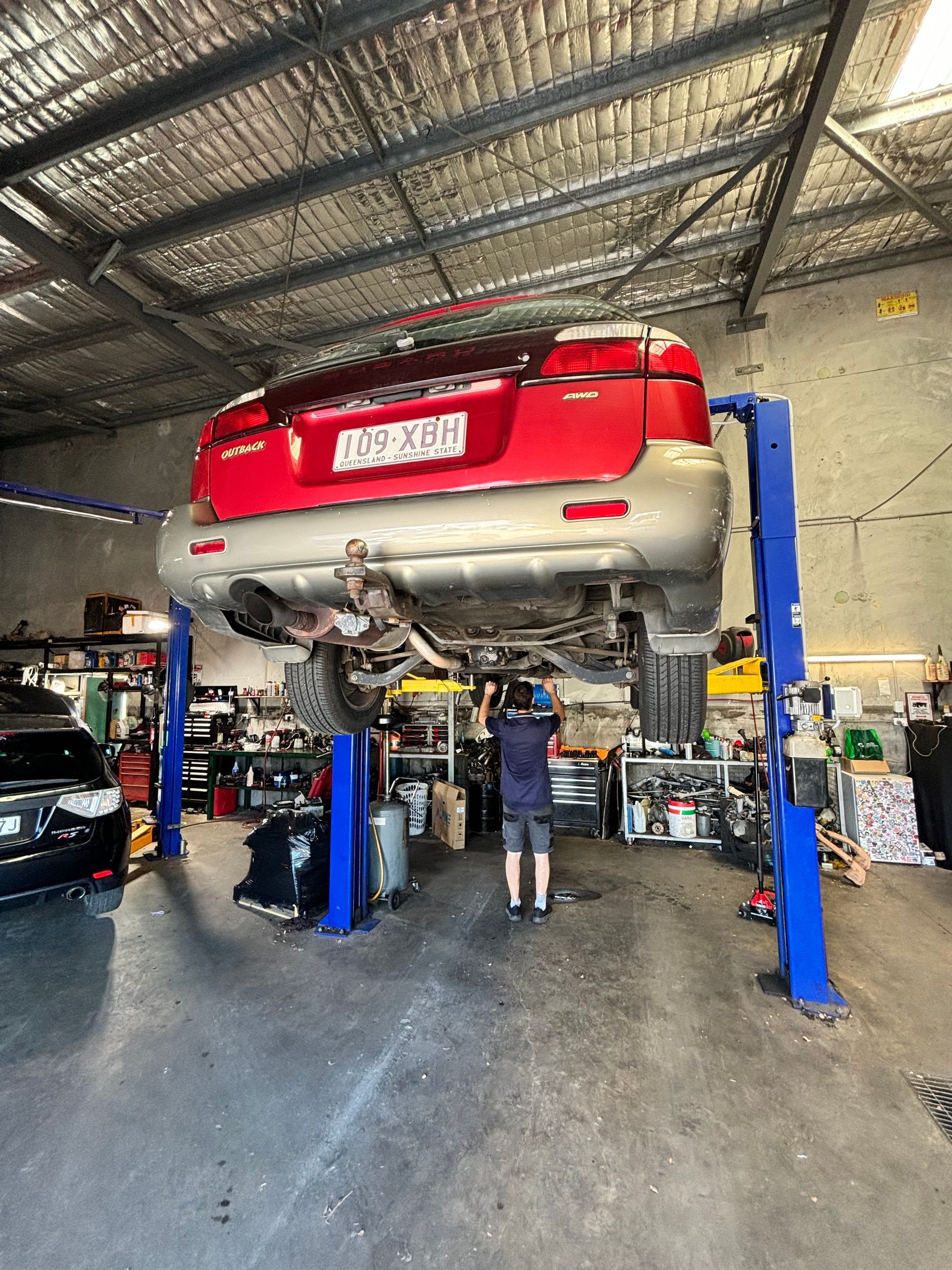 A Man Is Working On The Engine Of A Car — Subi Care Mechanical In South Murwillumbah, NSW