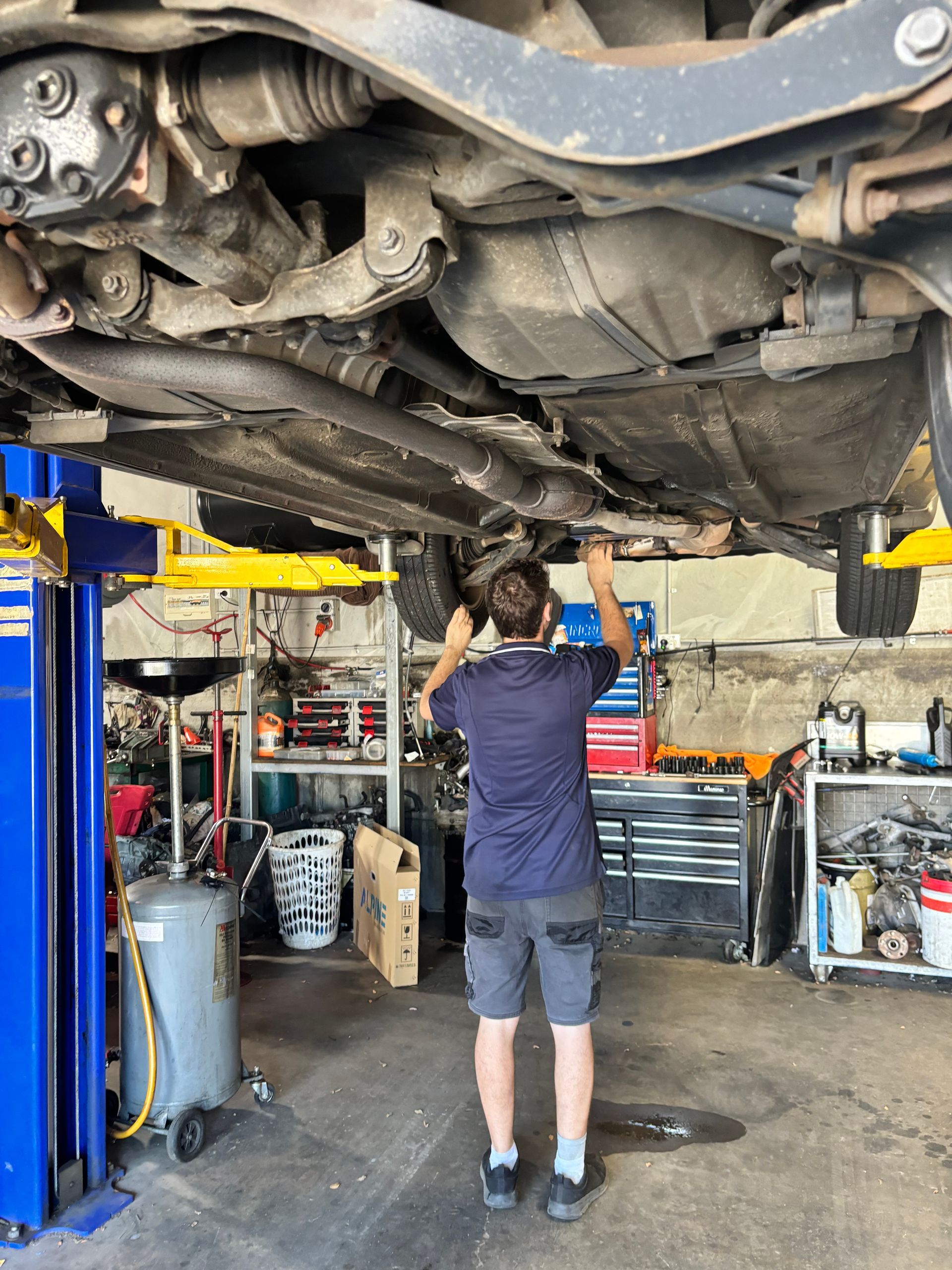 A Person Is Changing A Tire On A Car — Subi Care Mechanical In South Murwillumbah, NSW