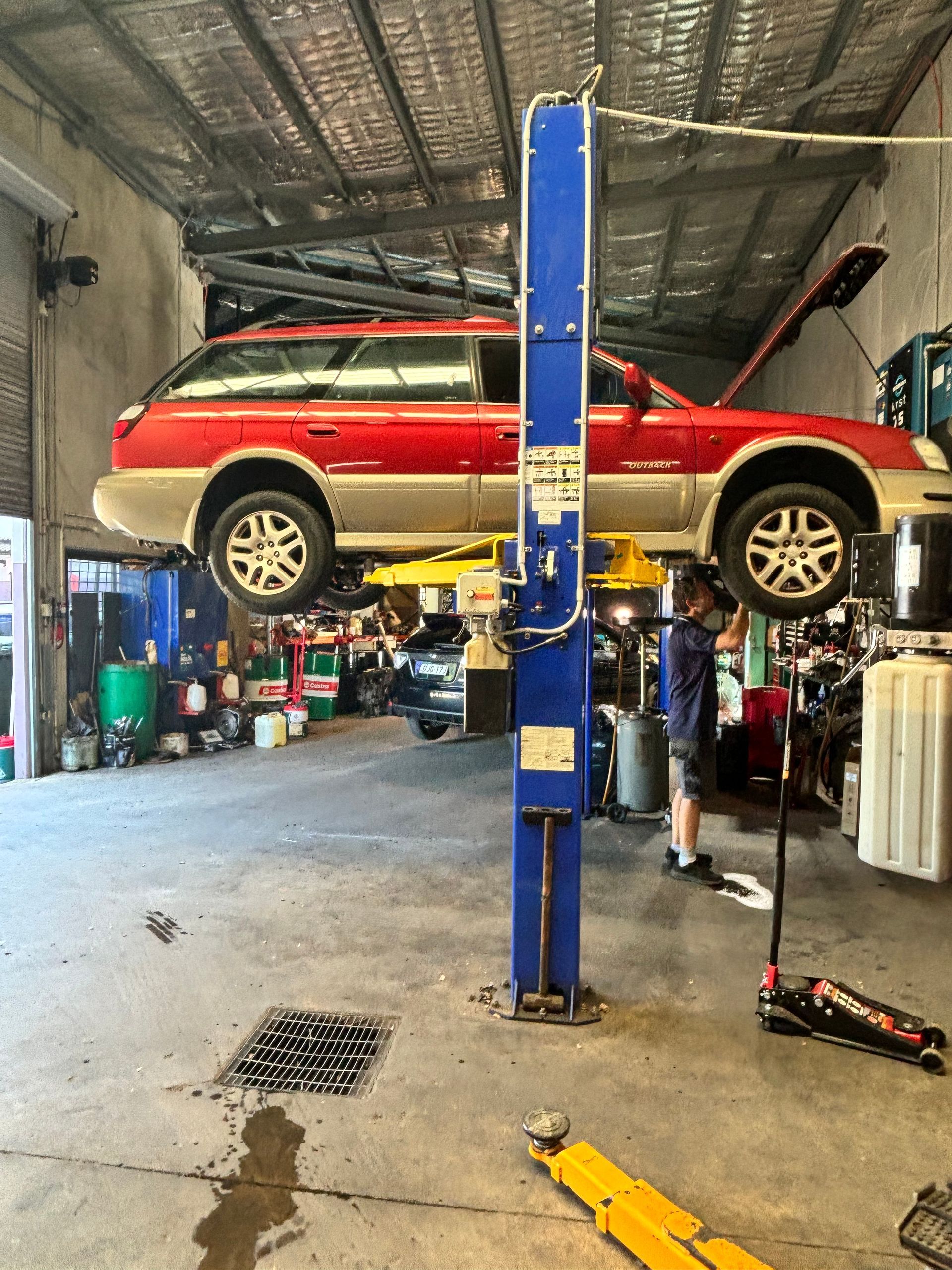 A Person Is Working On The Engine Of A Car — Subi Care Mechanical In South Murwillumbah, NSW