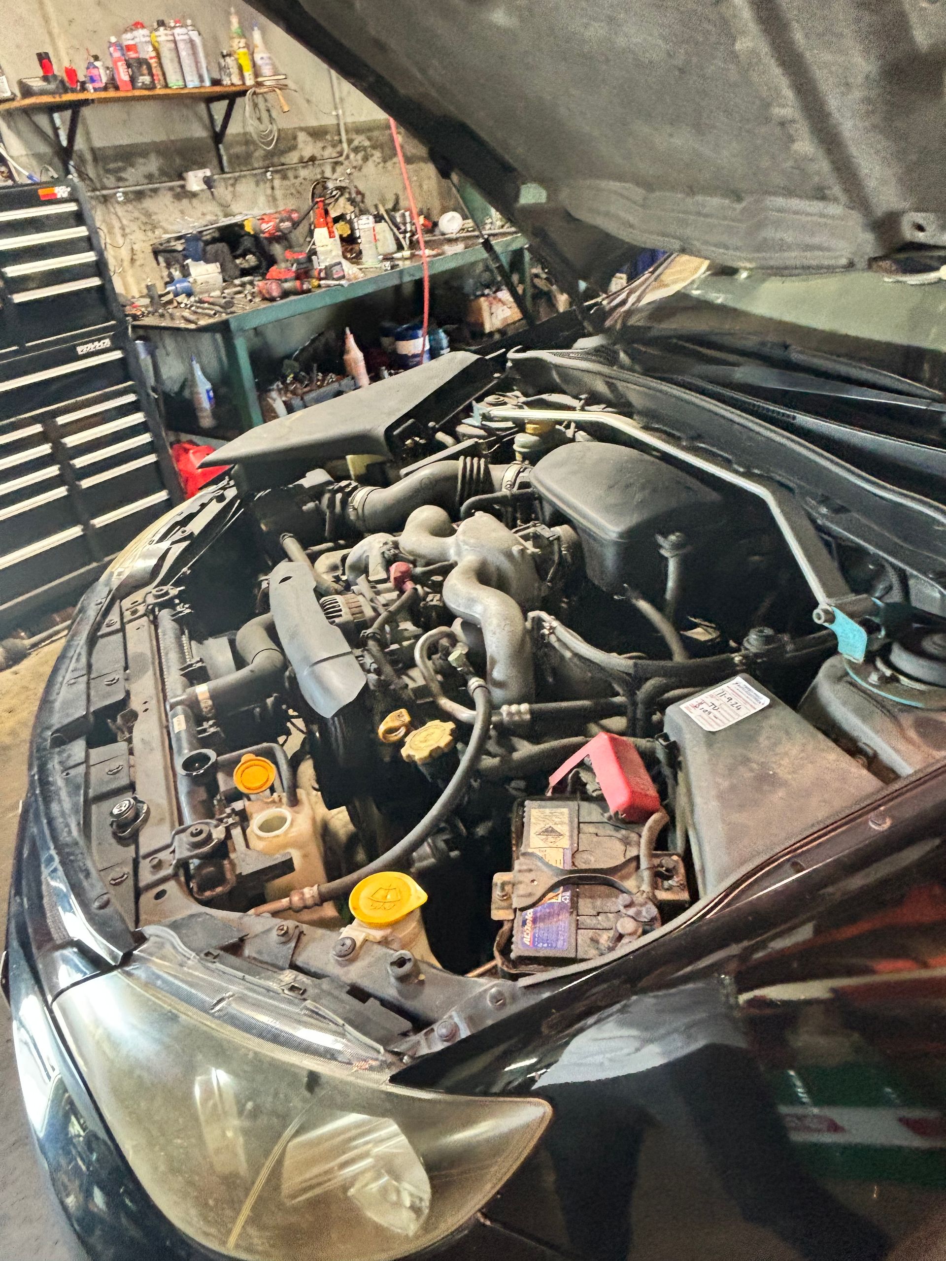 A Man Is Working On The Engine Of A Car — Subi Care Mechanical In South Murwillumbah, NSW