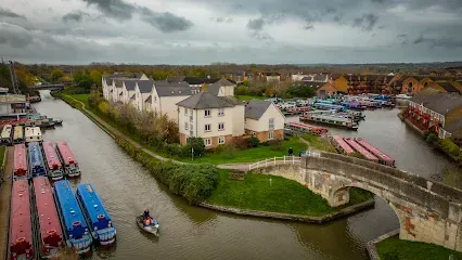 Canal with boats, bridge, and buildings on an overcast day.