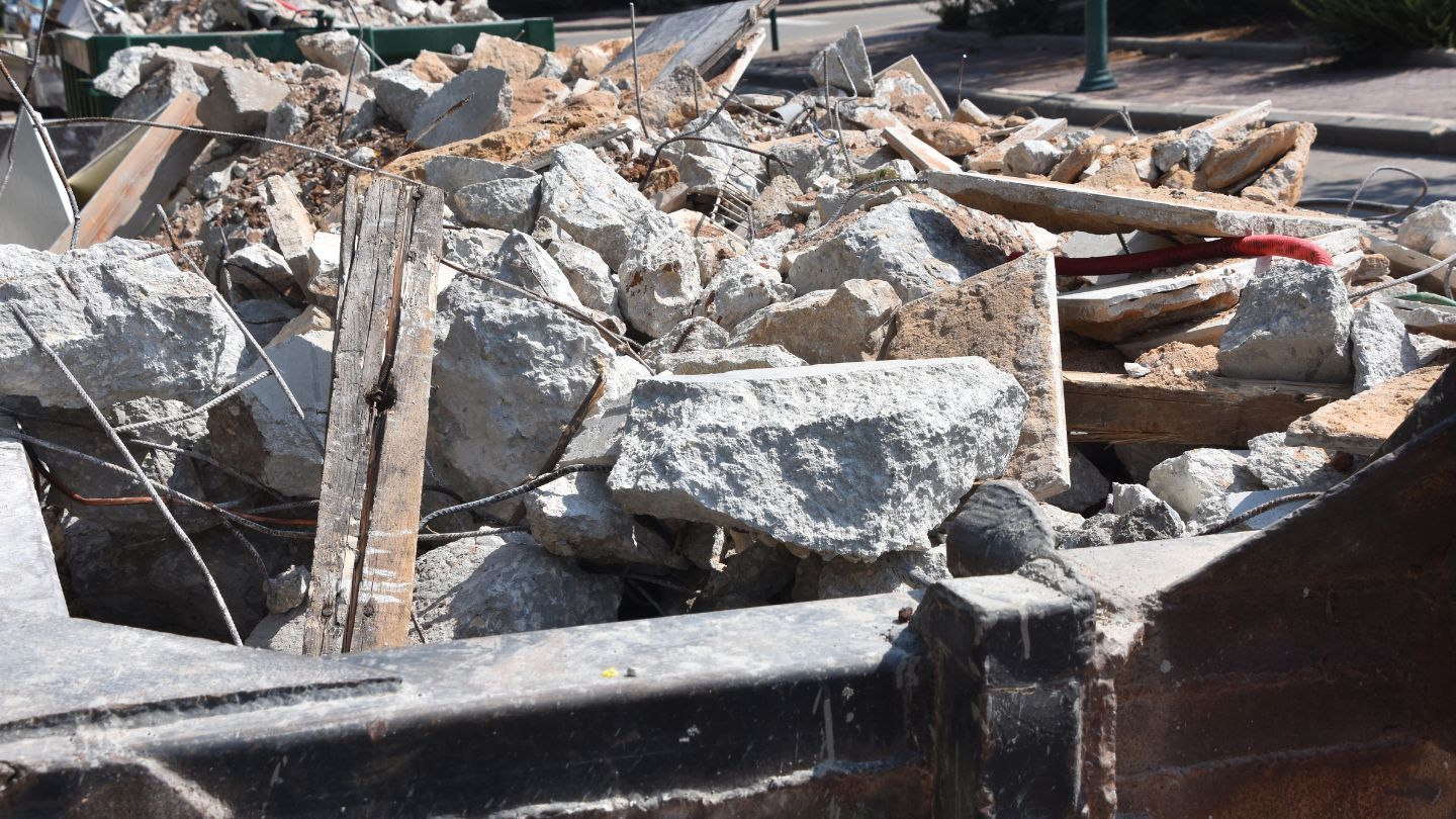 Pile of rubble and debris, likely from demolition, with concrete chunks and wooden beams.