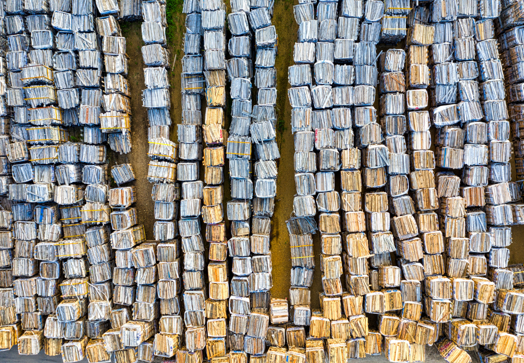 Overhead view of stacked rectangular wood blocks, organized in vertical rows. Mostly brown and gray tones.