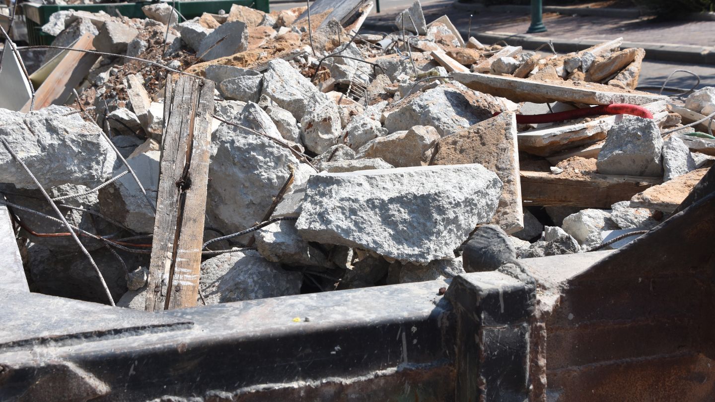Pile of broken concrete and debris in a metal container.