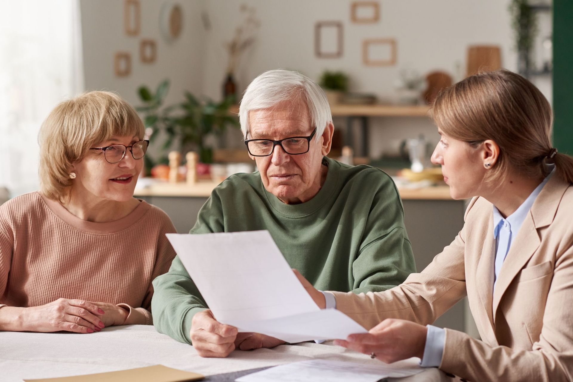 A man and a woman are sitting at a table looking at a piece of paper.