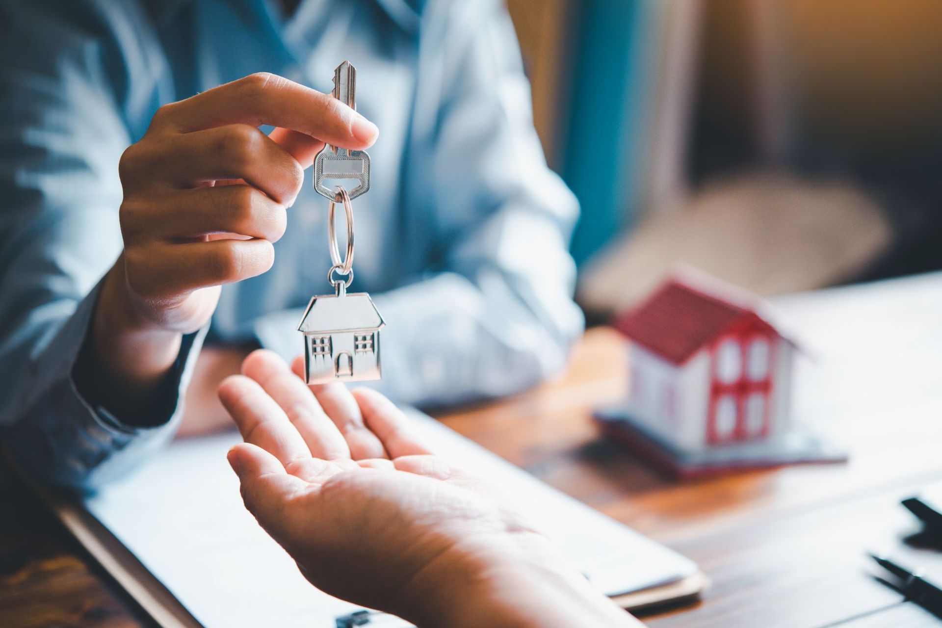 A man is giving a house key to a woman.