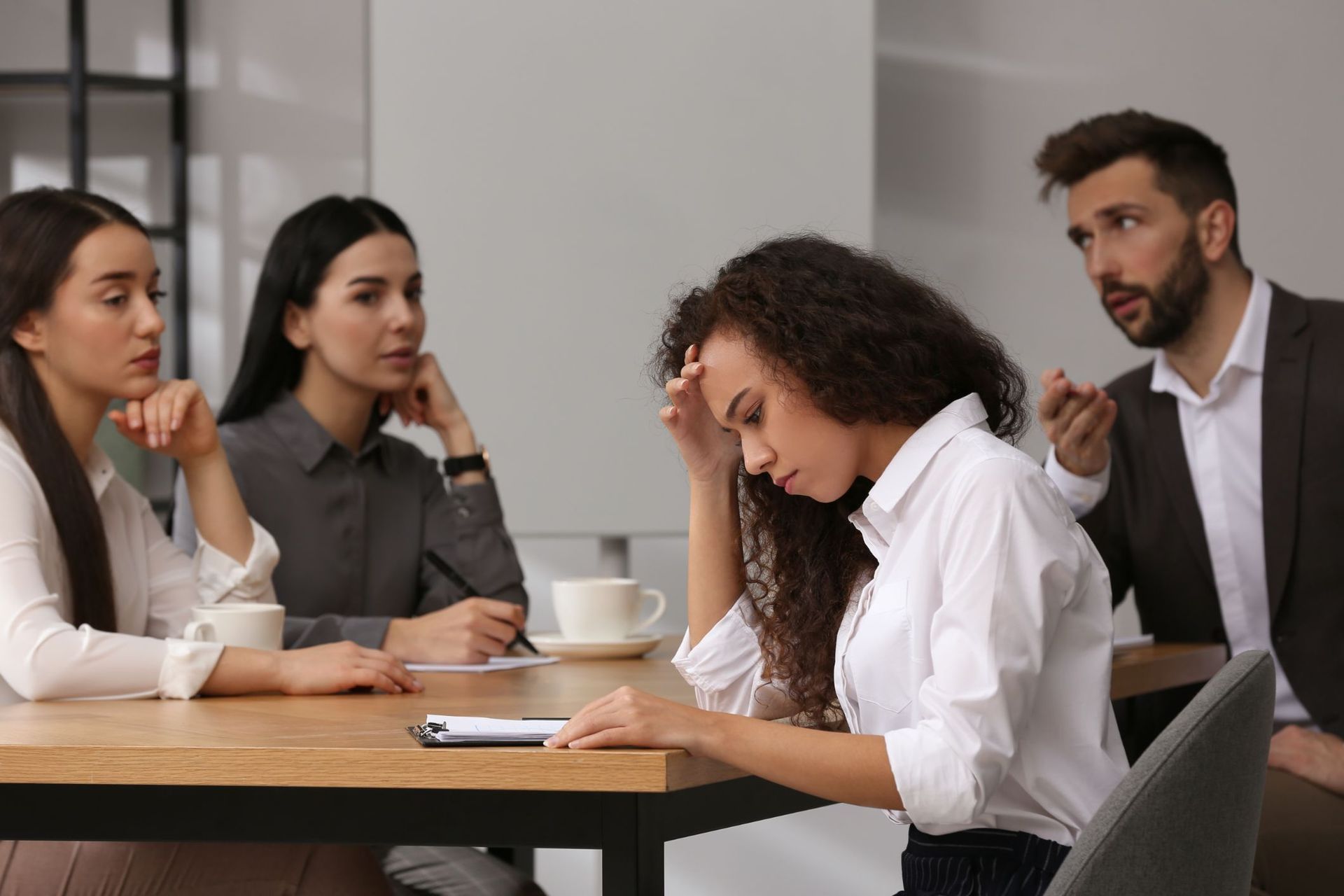A group of people are sitting around a table having a meeting.