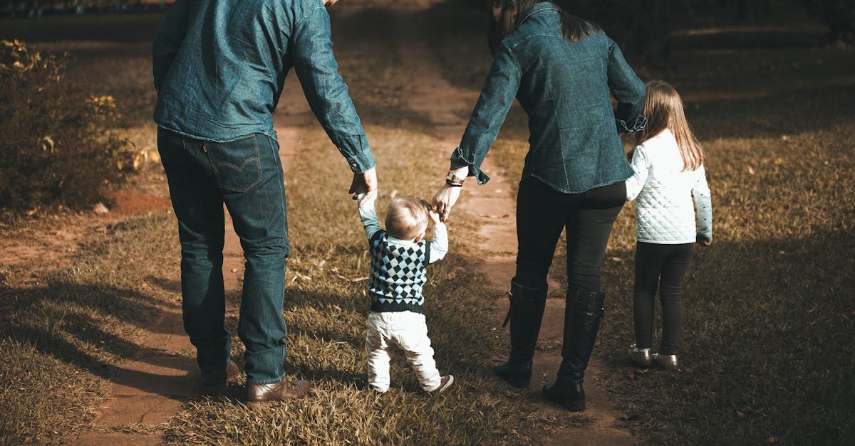 A family is walking down a path holding hands.