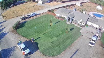 An aerial view of a lush green lawn in front of a house.