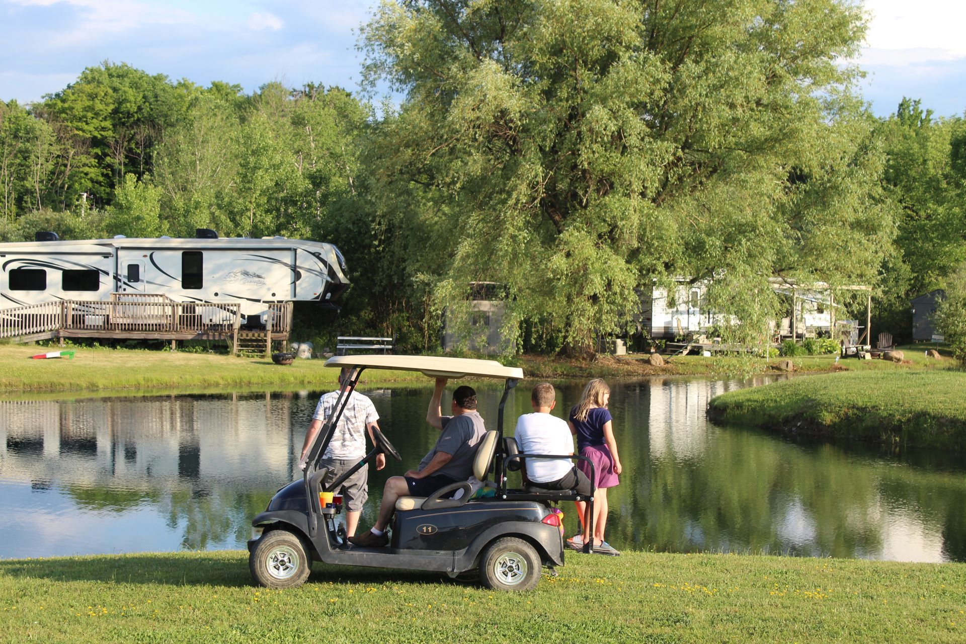 a group of people are riding a golf cart next to a lake .