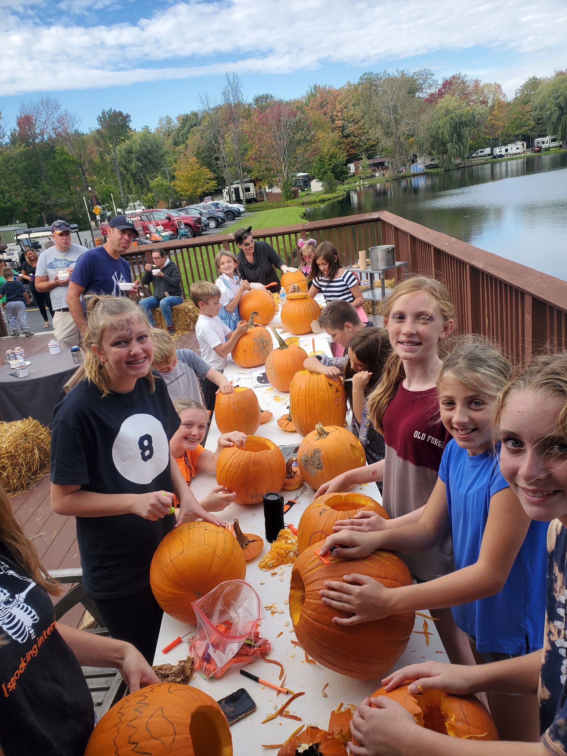 a group of children are carving pumpkins at a table .