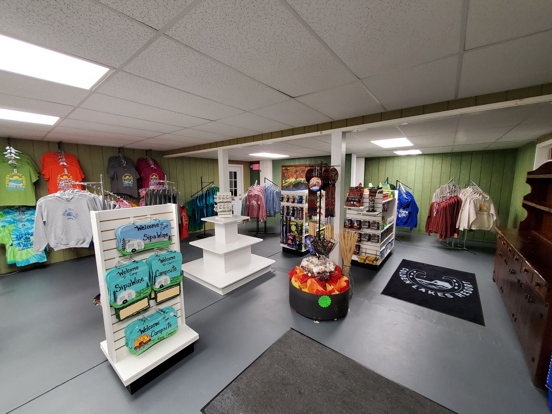 a store filled with lots of shirts and other items .