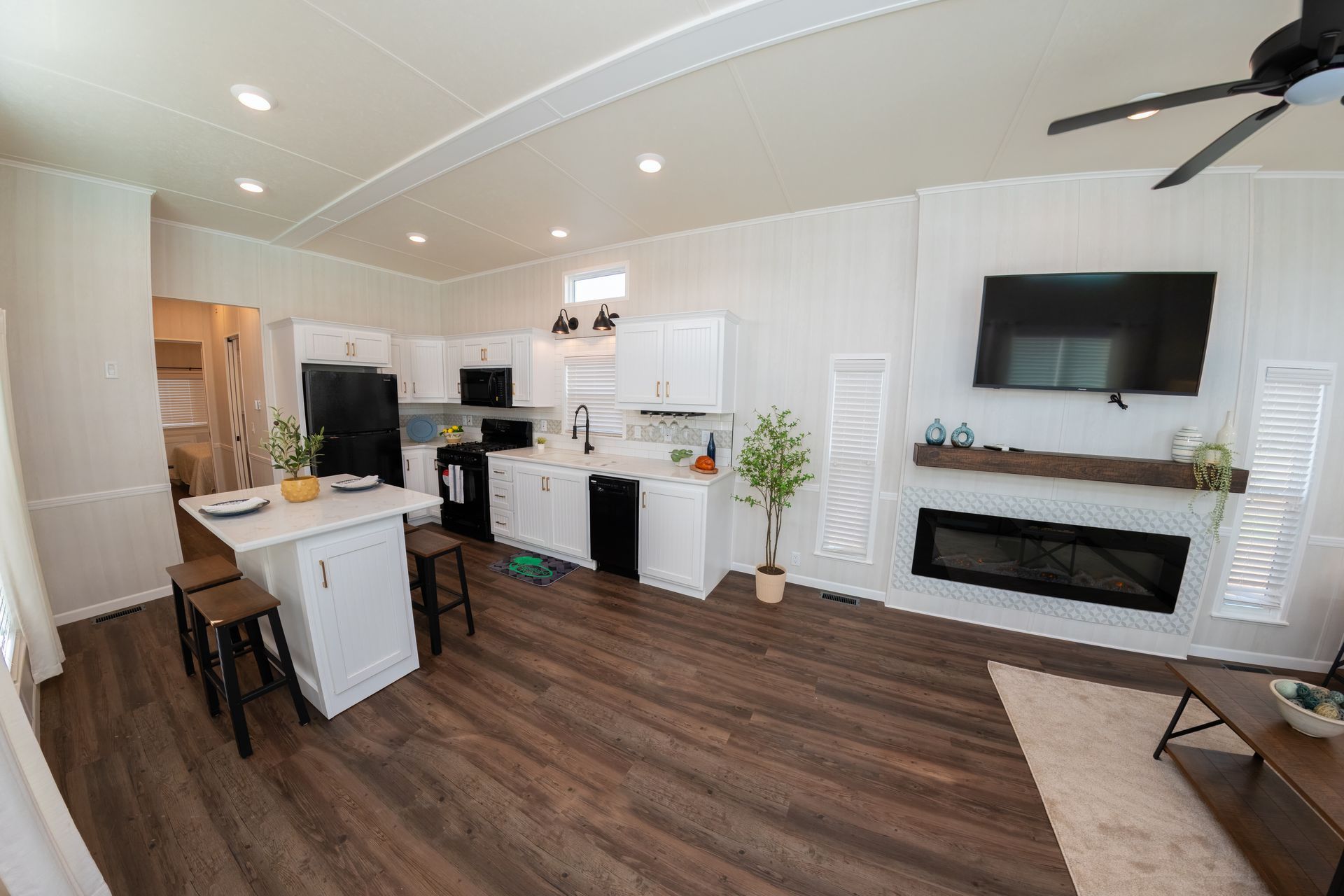a kitchen , living room , and fireplace in a mobile home .