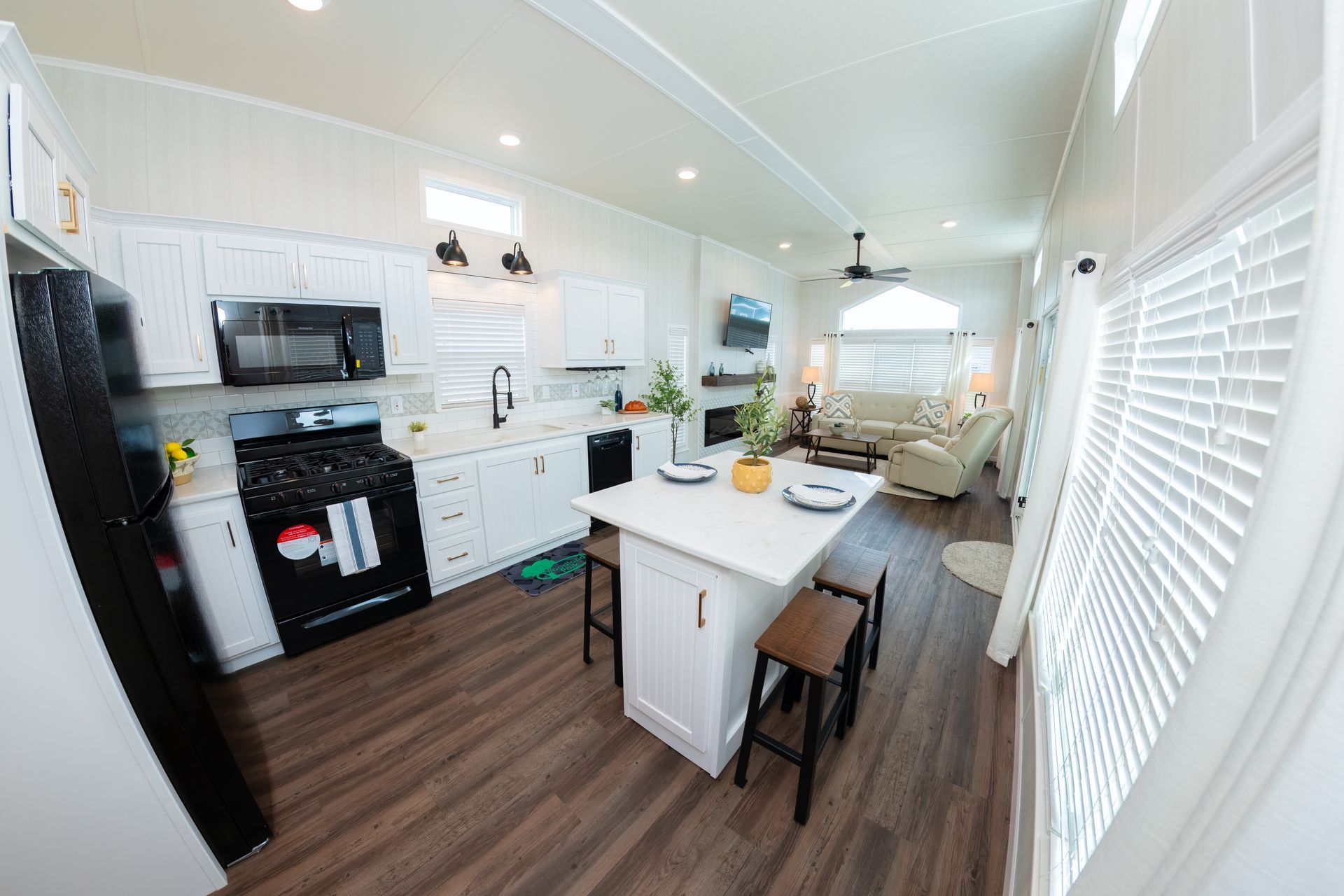 a kitchen in a mobile home with a large island in the middle .