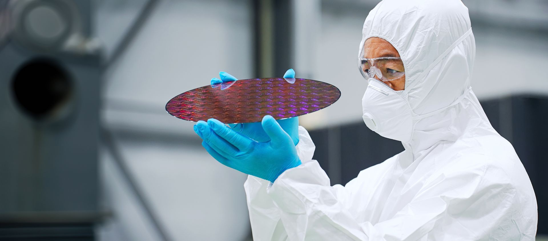Man holdig circle wafer in cleanroom