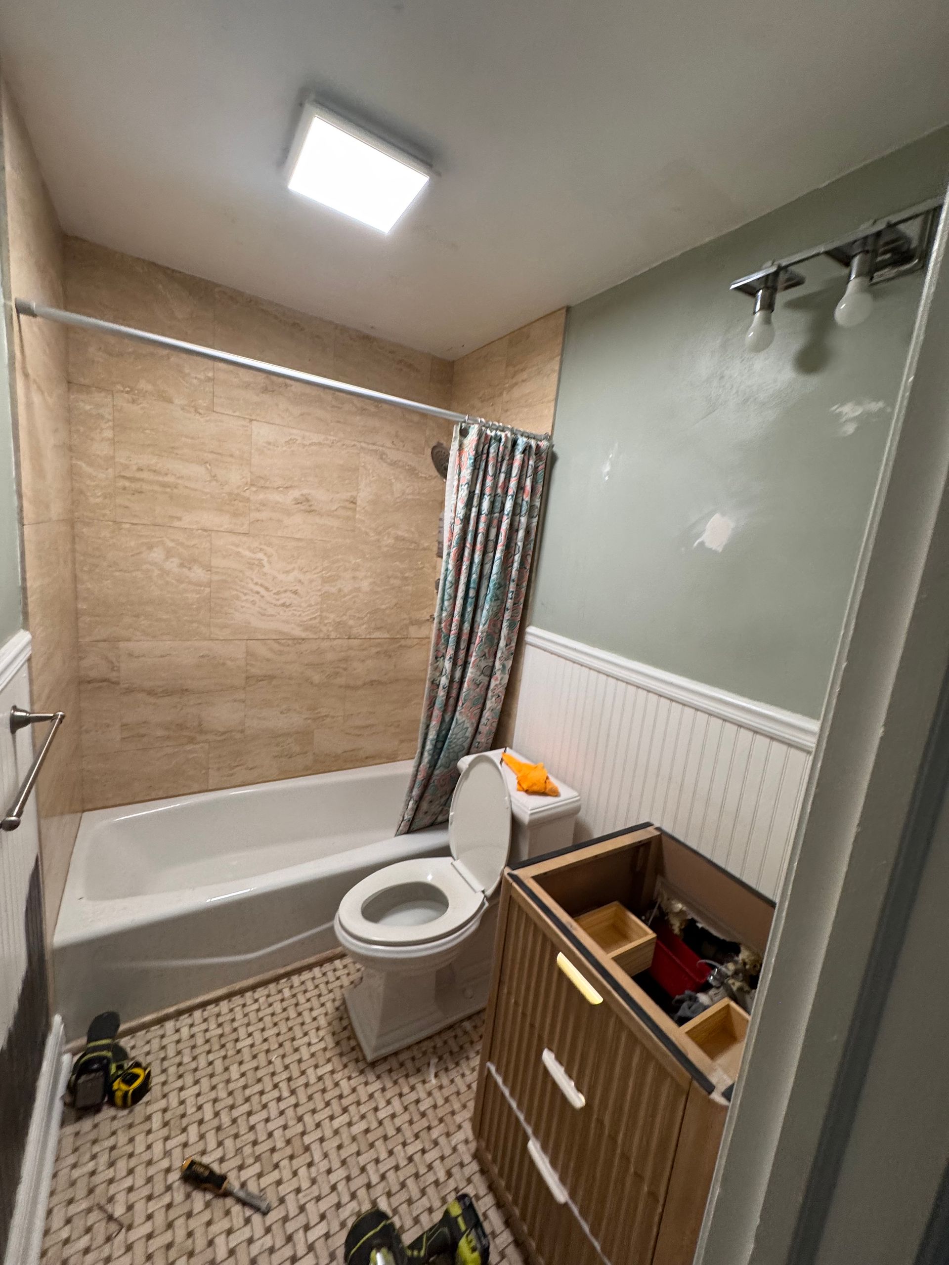 Pool with red robotic cleaner on the edge; debris floats in the water. Person stands nearby.