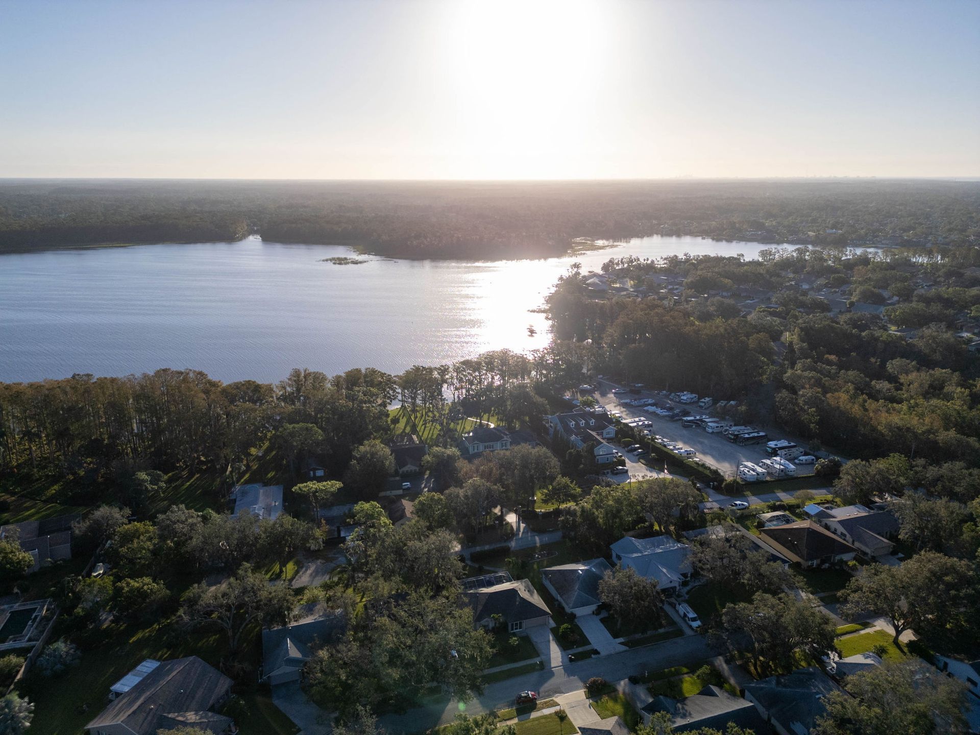 Row of modern townhouses with colorful exteriors, green lawns, and blue sky.