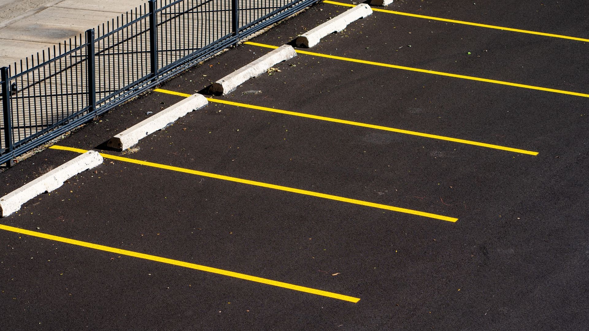 A parking lot with yellow lines and white curbs