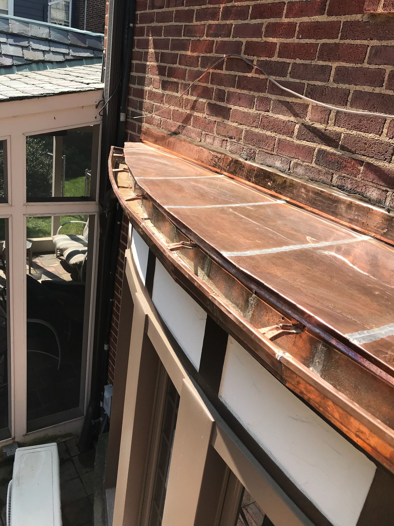 A gutter is attached to the side of a building with a tiled roof