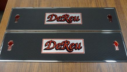 Two rectangular black truck fender panels with "DeReu" logos and red truck emblems.